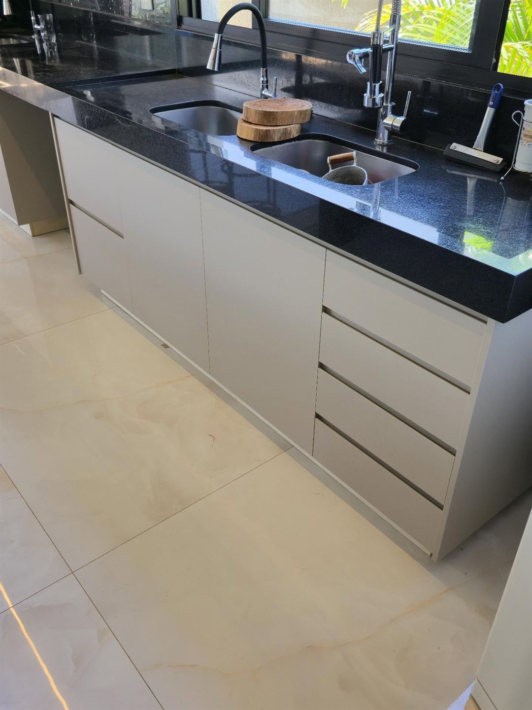 Cozinha planejada com ilha, frentes off-white e tampo de granito preto e dourado